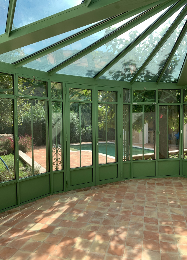 Véranda verte sur mesure avec vue piscine — réalisation de Maeva Jay, architecte à Hyères